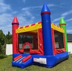 Full view of castle moon bounce house, orange, yellow, blue, green & blue castle.